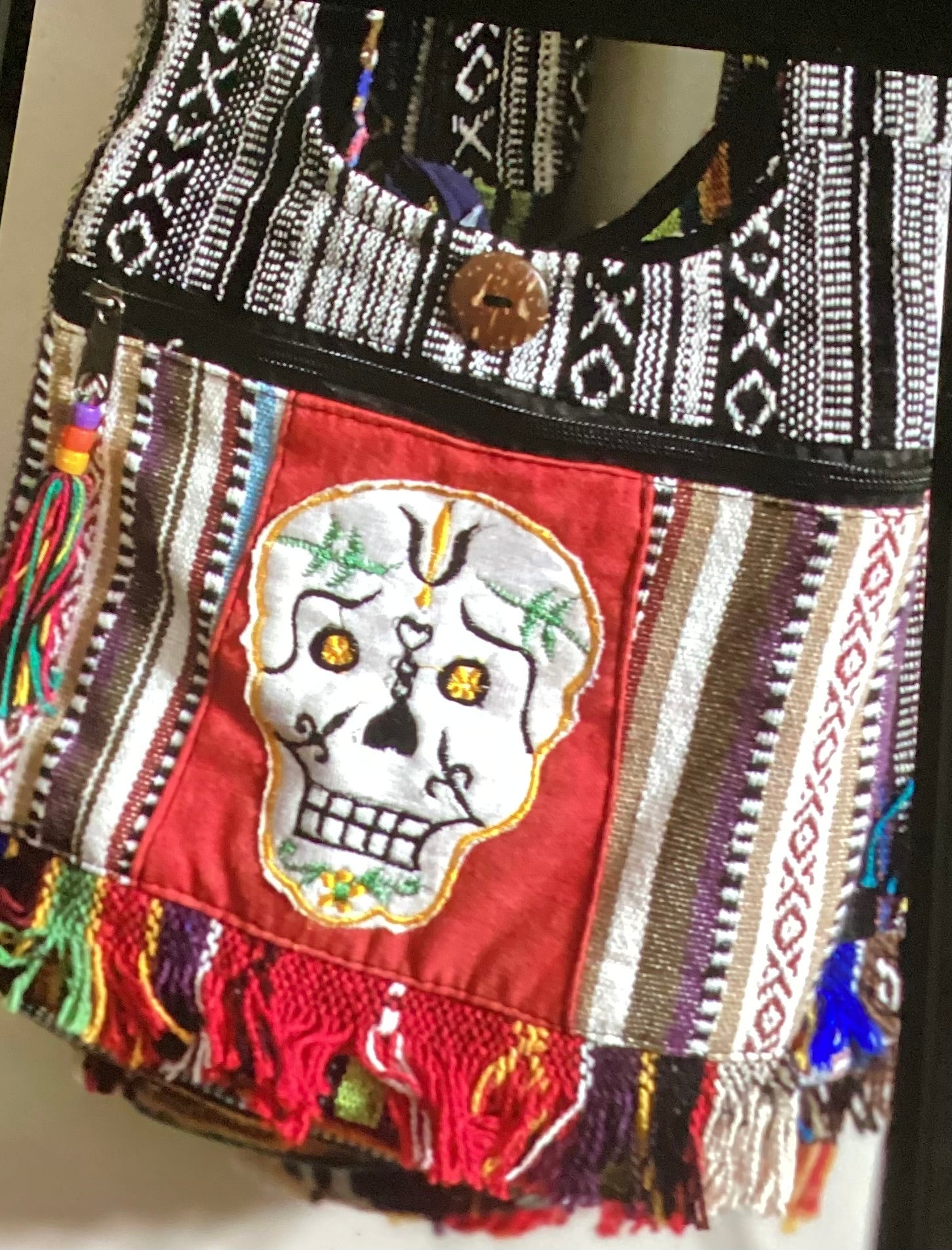 Medium skull tote bag. Button closure with several pockets and fringe on bottom