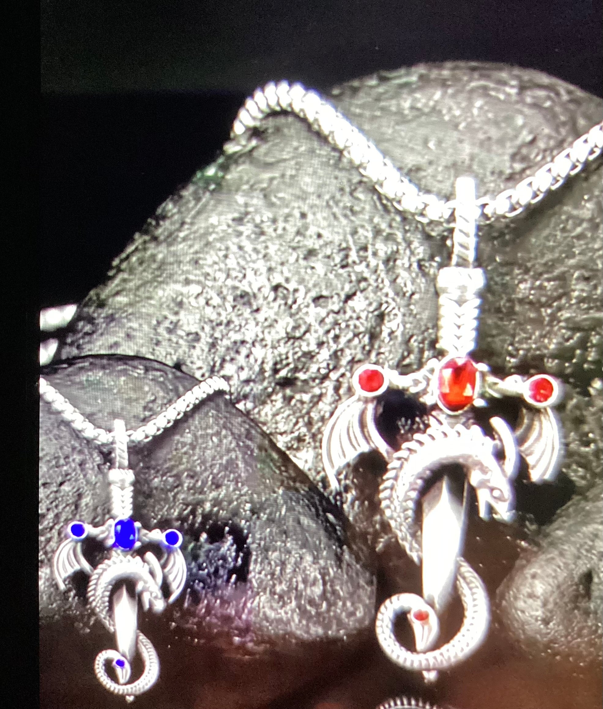 Necklace dagger with a dragon wrapped around it and a few colored stones